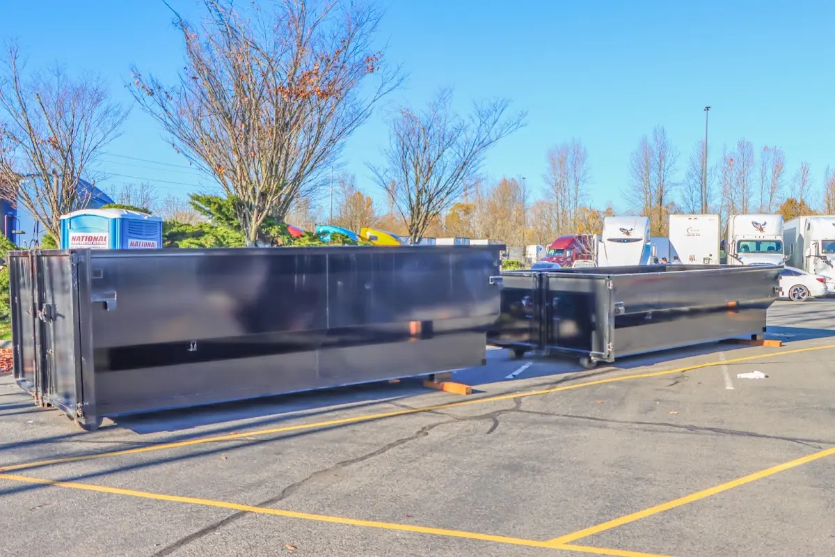 Professional dumpster rental service with roll-off container on residential driveway in East Los Angeles